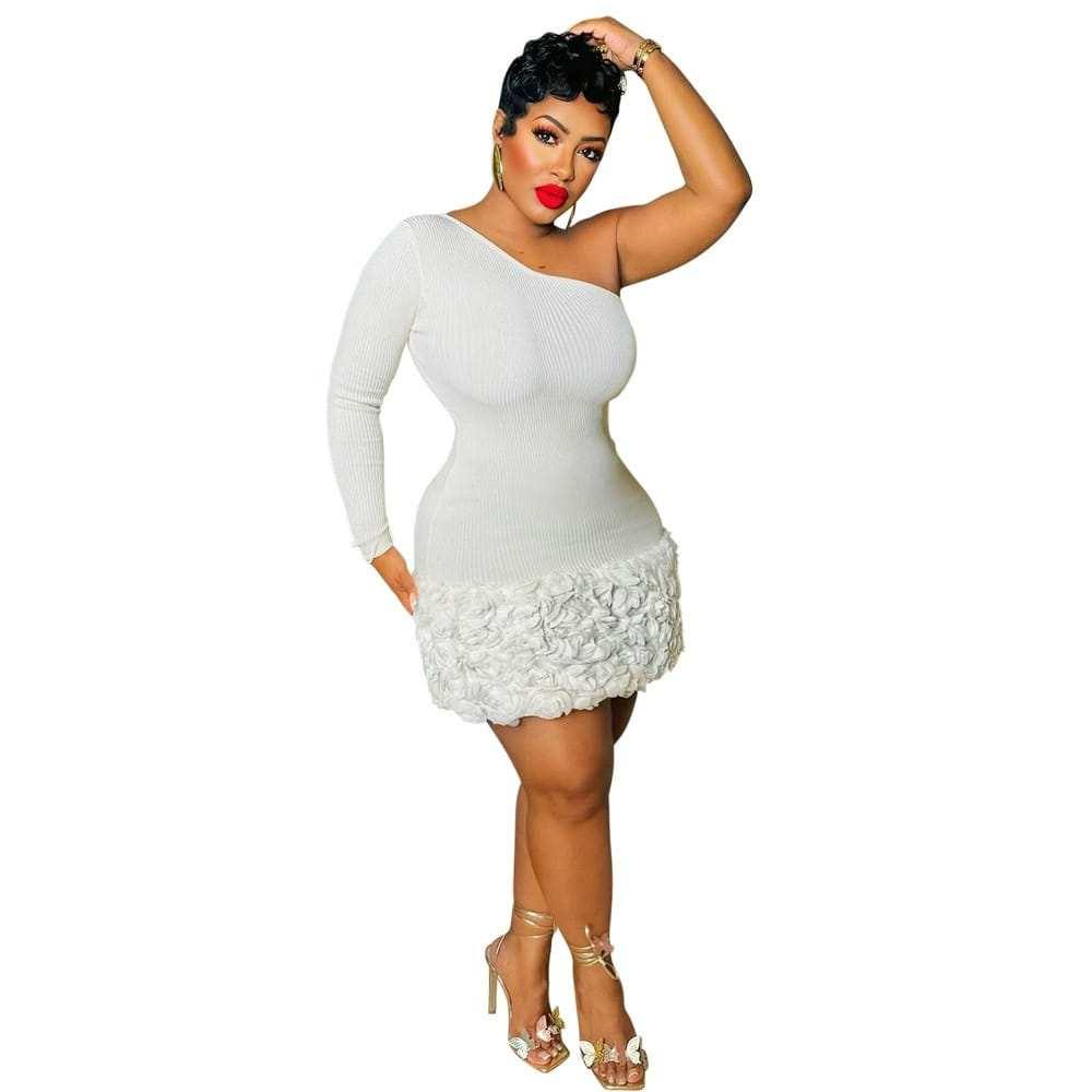 Woman wearing white one-shoulder bodycon mini dress with textured floral hem and heels