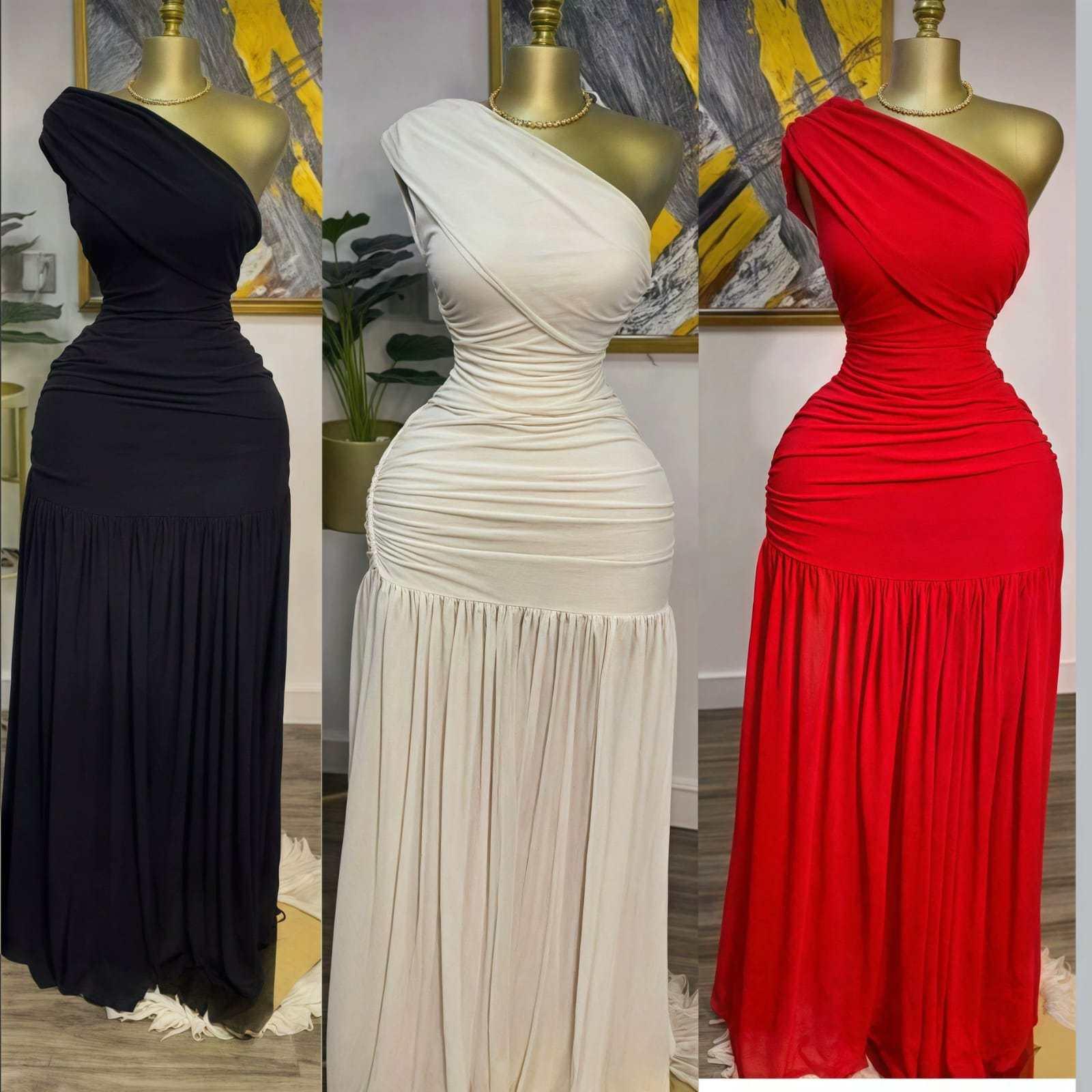 Three mannequins wearing one-shoulder ruched maxi dresses in black, white, and red.