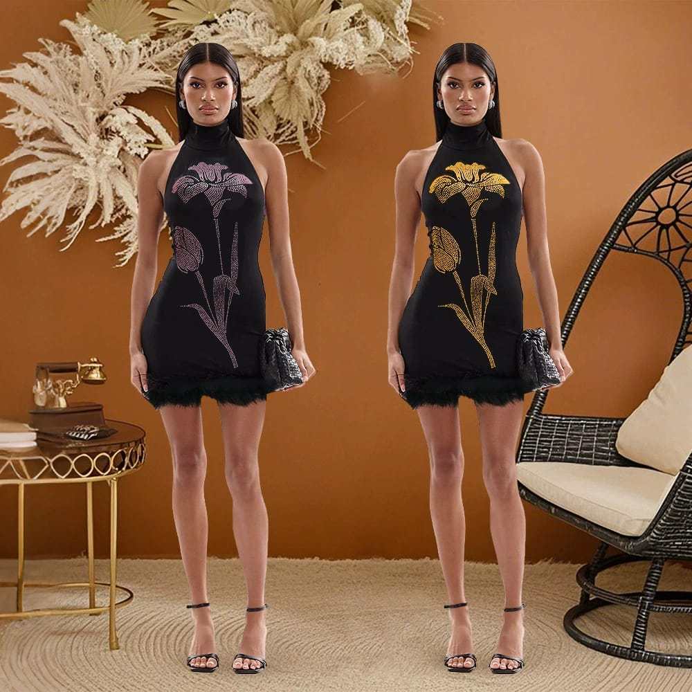 Woman in a black halter mini dress with floral rhinestone design, standing in a modern living room with pampas grass decor.