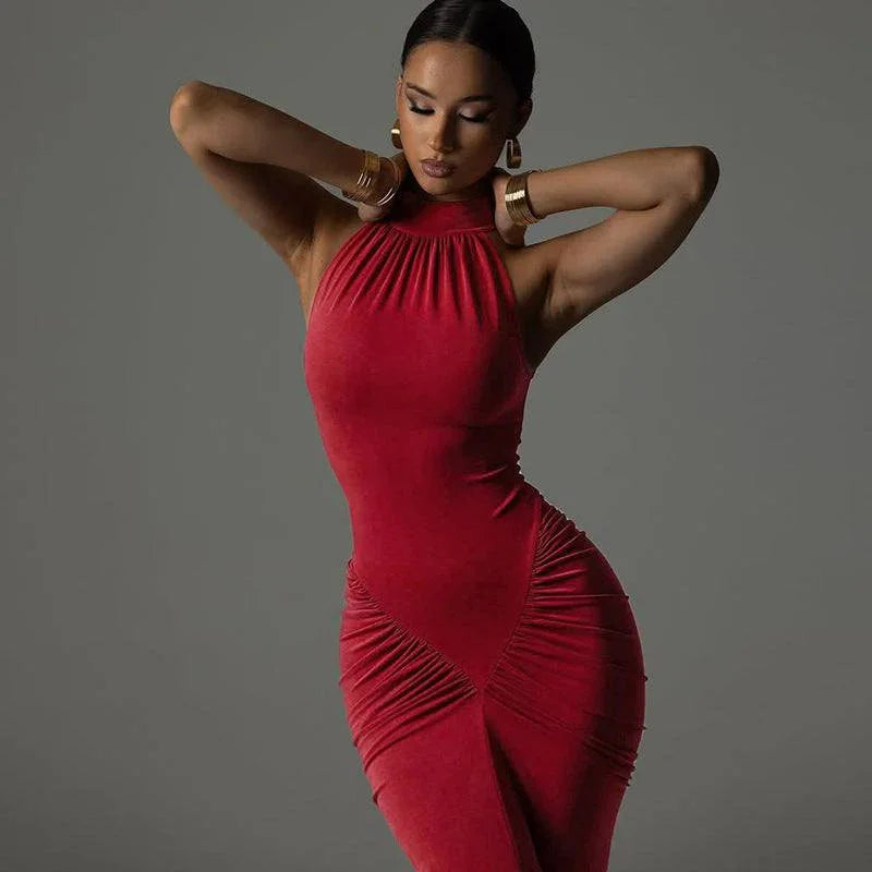 Woman in a fitted red halter-neck dress posing against a gray background, elegant fashion