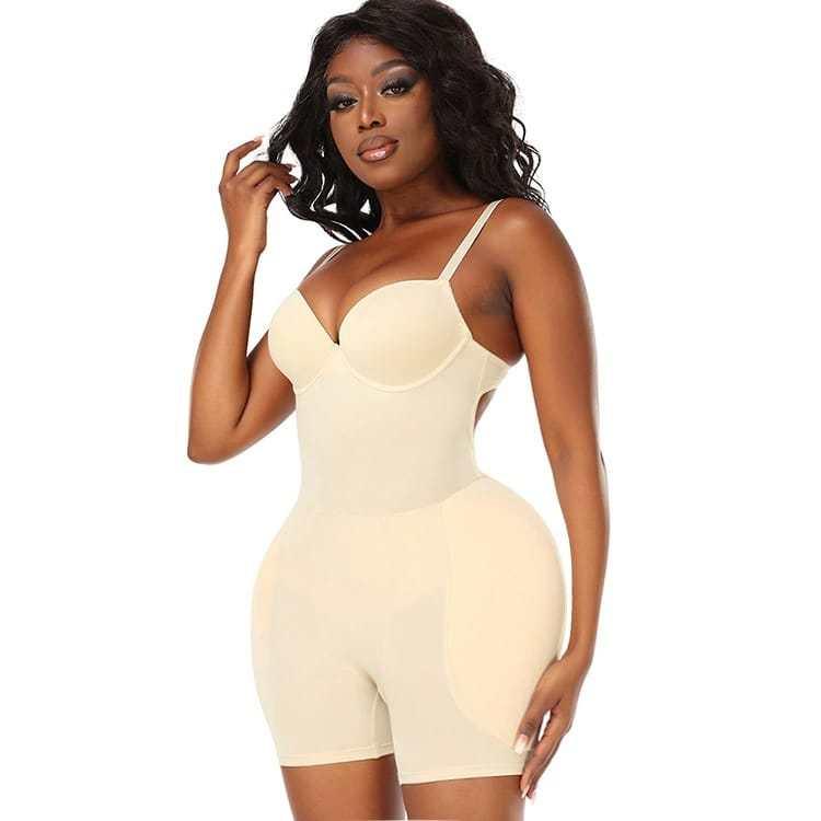 Woman wearing beige seamless shapewear bodysuit with padded hips, confident pose