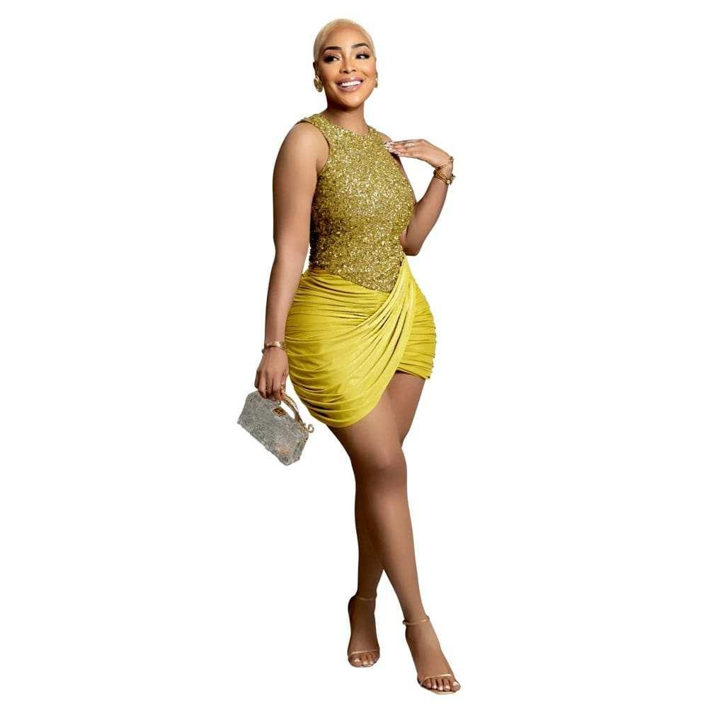 Woman in a sleeveless gold sequin top and yellow ruched mini skirt, holding a small purse