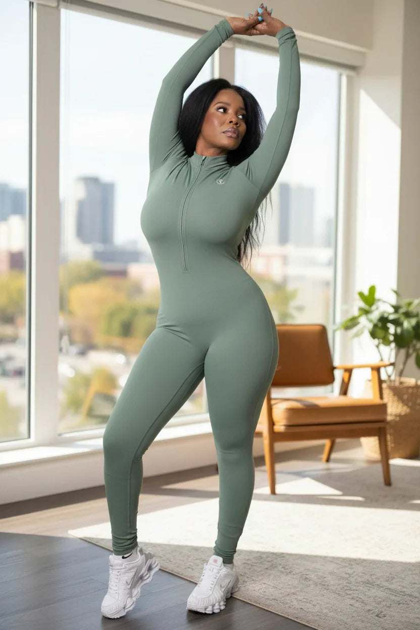 Woman posing indoors in green full-body athletic jumpsuit, white sneakers, natural light