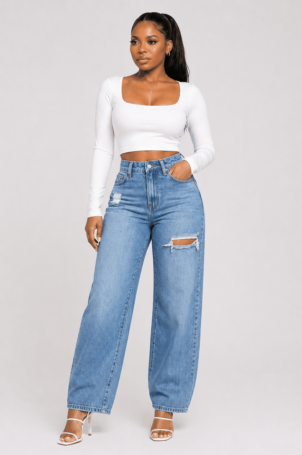 Wide-leg denim jeans with high-rise waist and distressed detailing in light blue wash